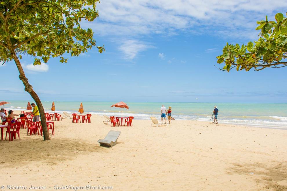 Imagem de mesas e guarda sol nas areias da Praia de Itacimirim.